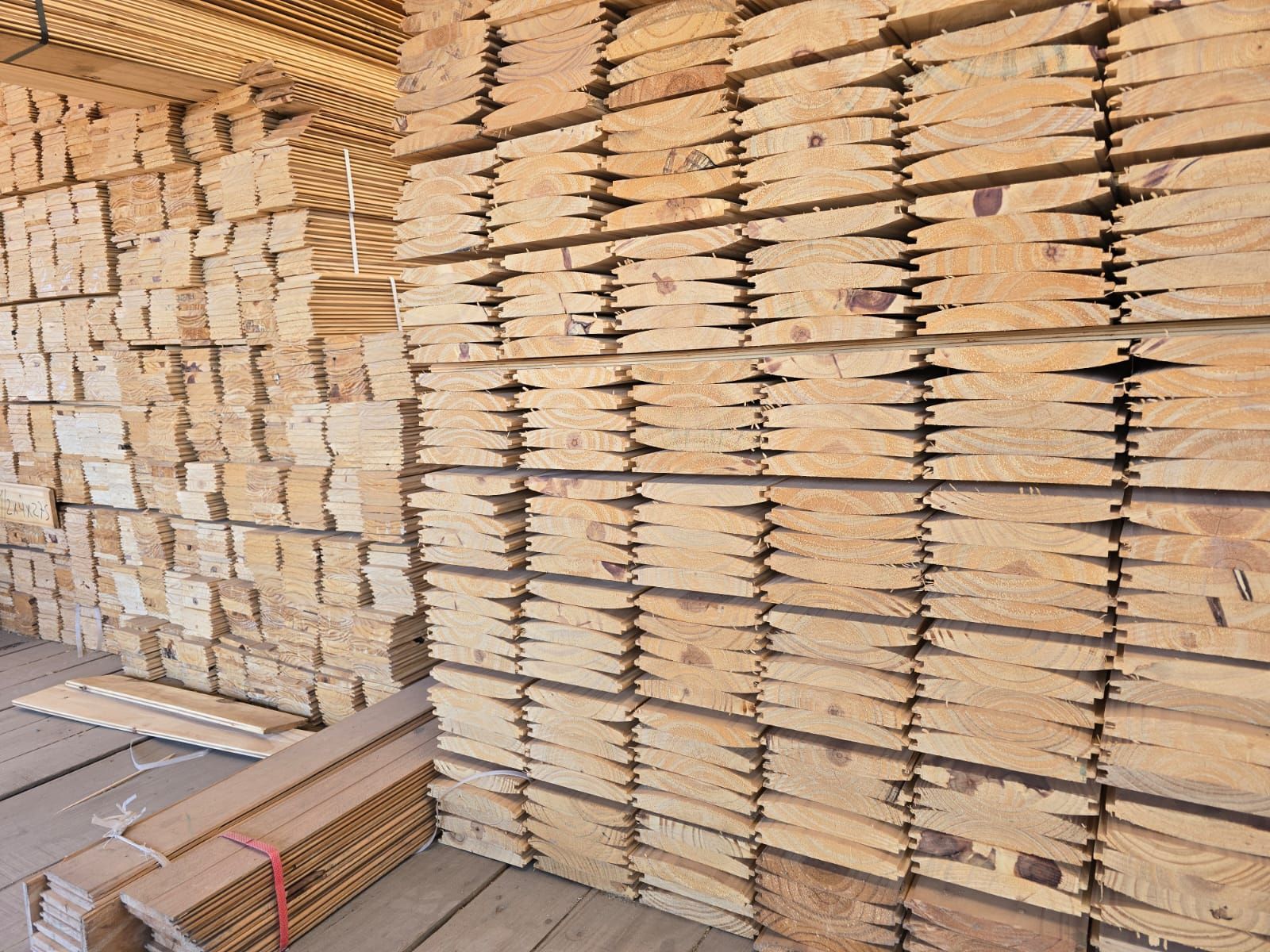 Un almacén lleno de muchas tablas de madera apiladas una encima de otra.