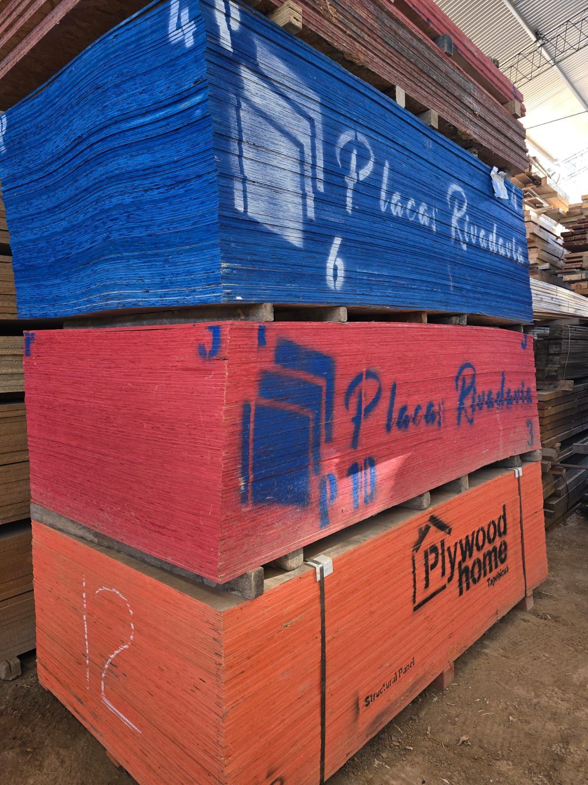 Una pila de madera contrachapada está colocada una encima de otra en un almacén.