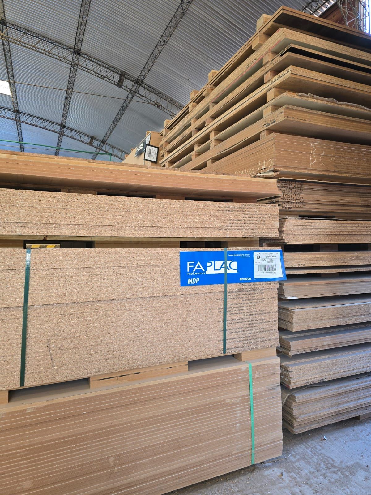 Un almacén lleno de montones de paletas de madera apiladas una encima de otra.