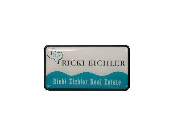 Domed thermal printed name badge set in a black executive frame, for a real estate firm.