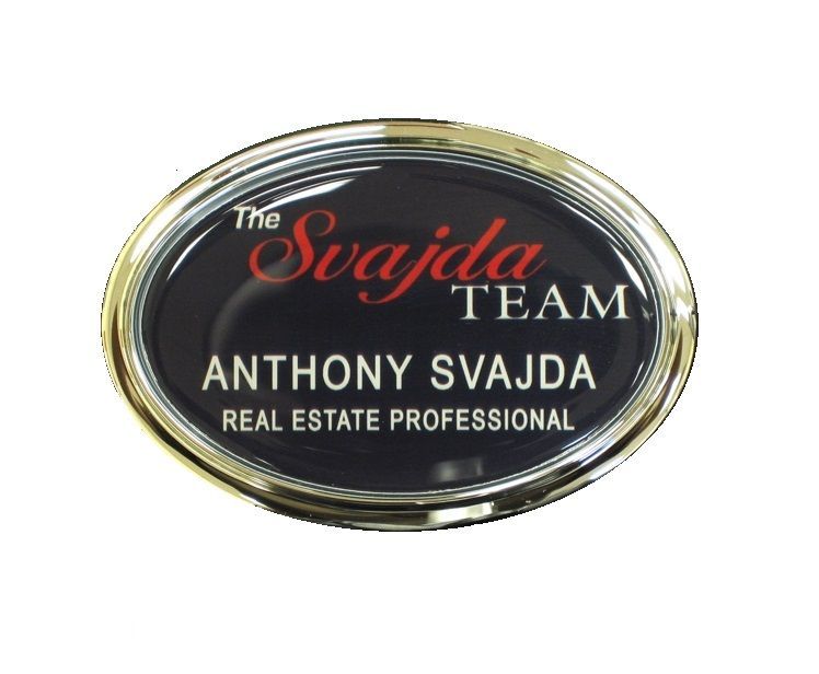 Domed thermal printed name badge set inside a gold oval frame, for a real estate firm.