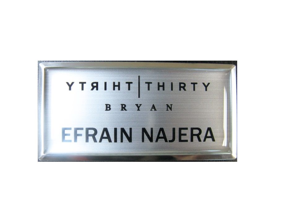 Laser engraved name badge with protective dome on large silver premier frame.