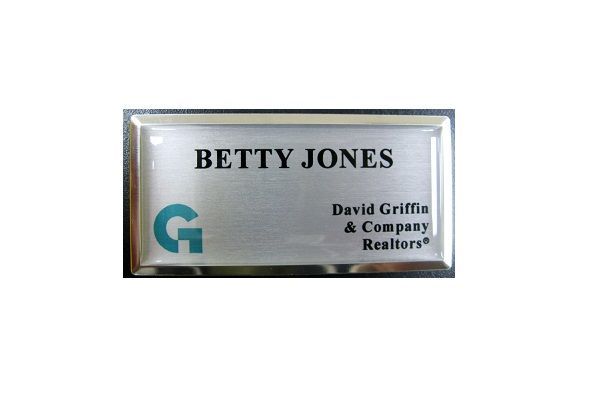 Sublimated brushed aluminum name badge with protective dome on large silver premier frame.