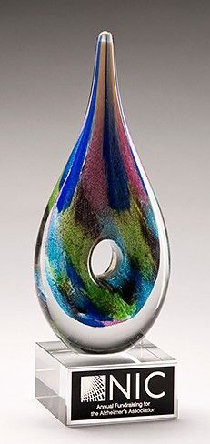 Colorful glass teardrop shaped art glass award with center hole.