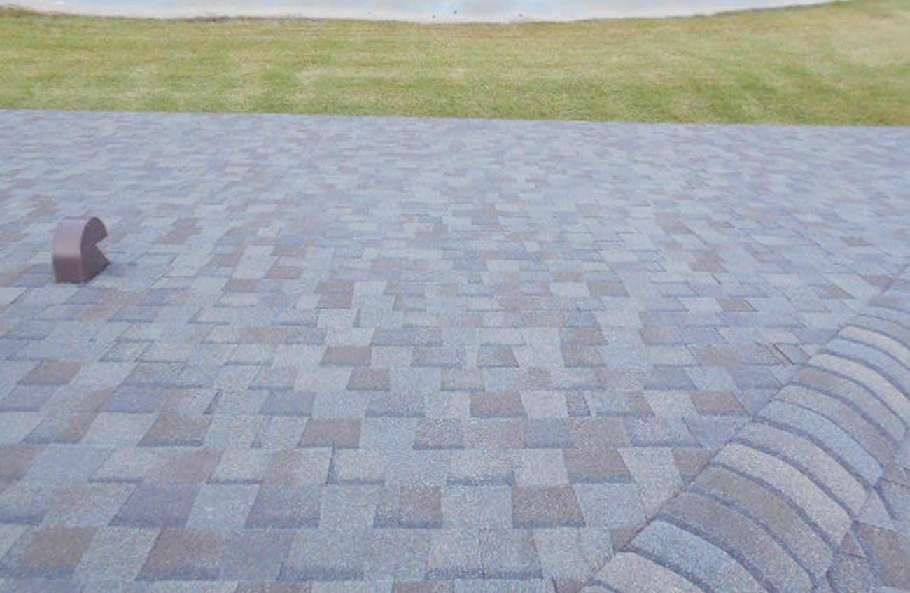 A brick walkway is being built next to a grassy field.