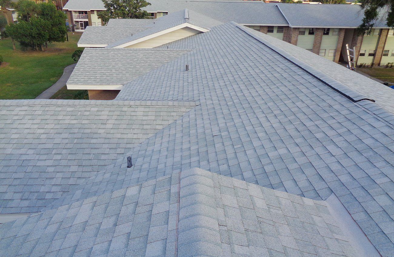 A roof of a house with a gray shingle roof.