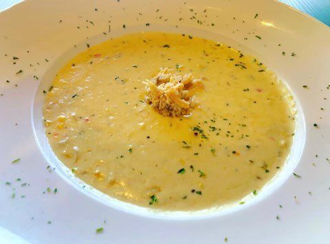 Creamy soup with a dollop of garnish in a white bowl.