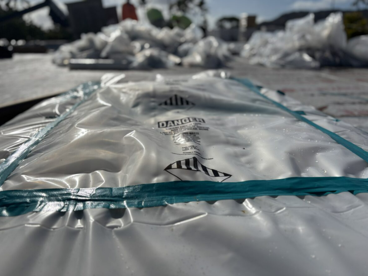 White plastic bag with warning label, more bags in the background.