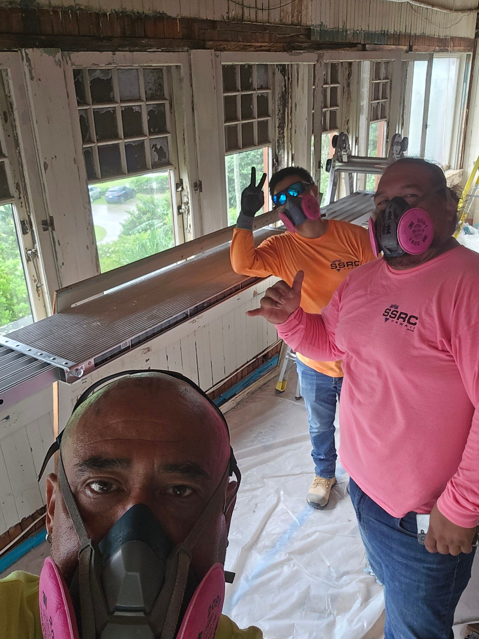 Exterior view of old building with weathered wooden beams, windows, and peeling paint.