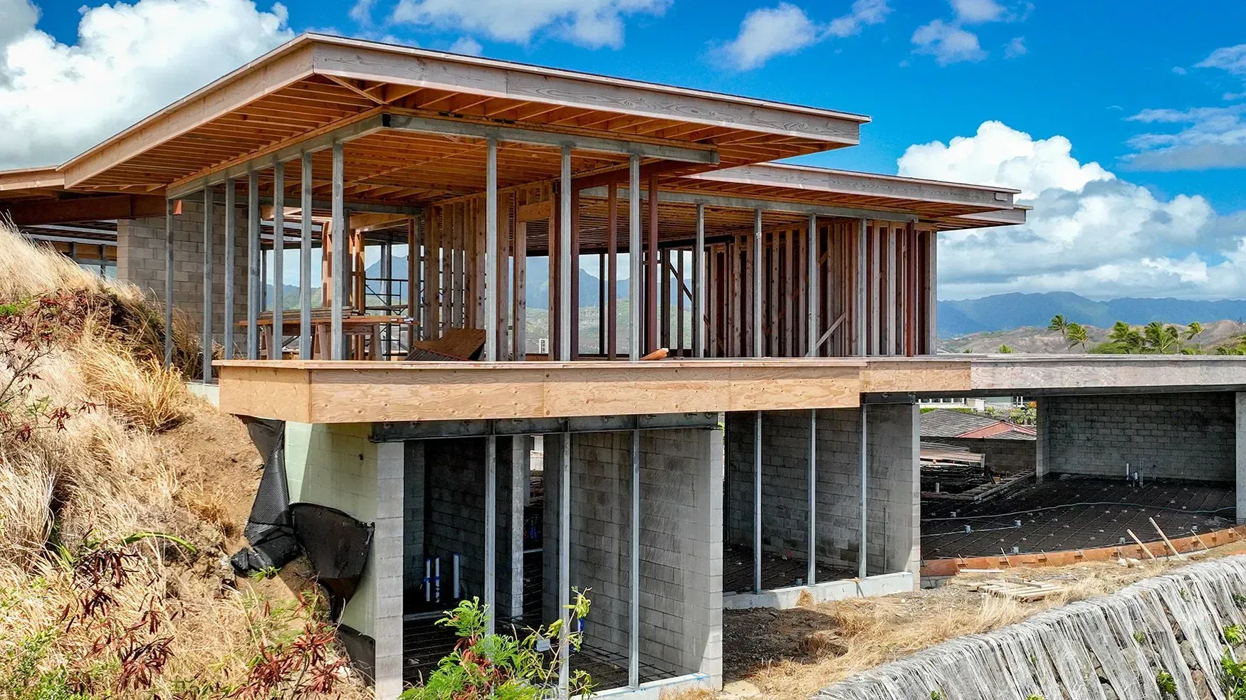 House under construction, wooden frame structure, with mountain view.