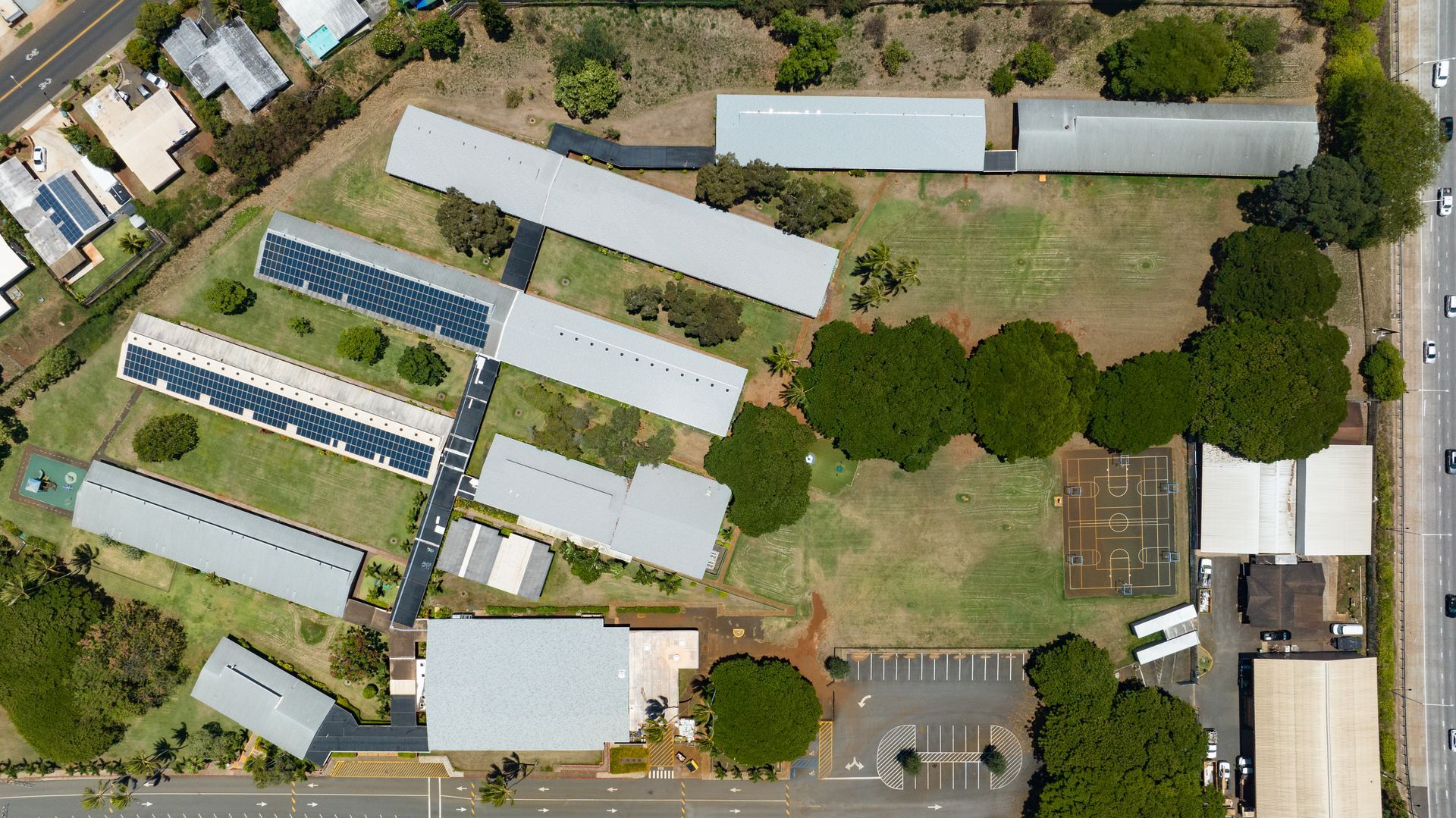 Overhead view of a school campus with various buildings, green spaces, and solar panels.