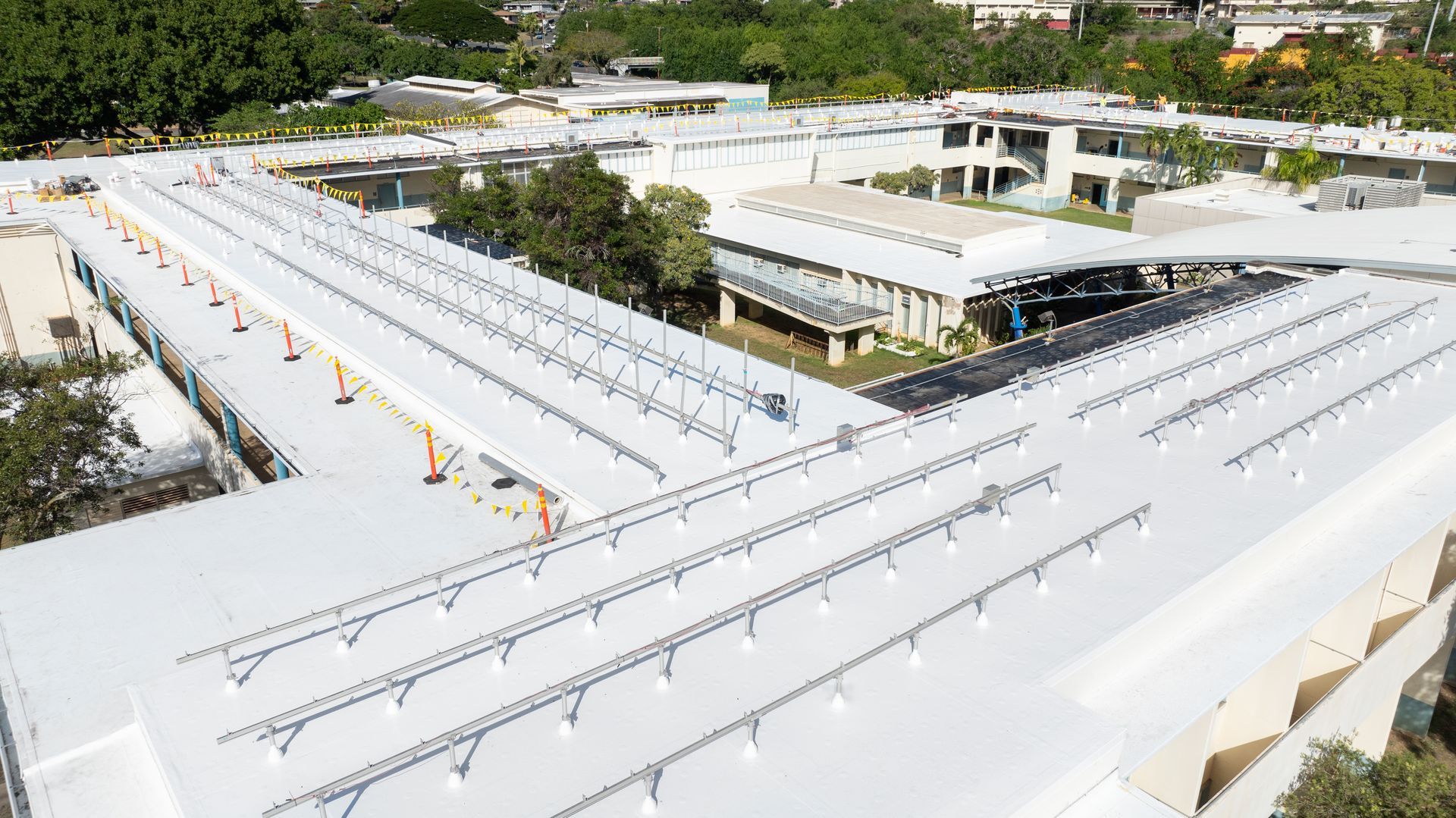 Overhead view of a building roof with rows of solar panel mounting racks installed.