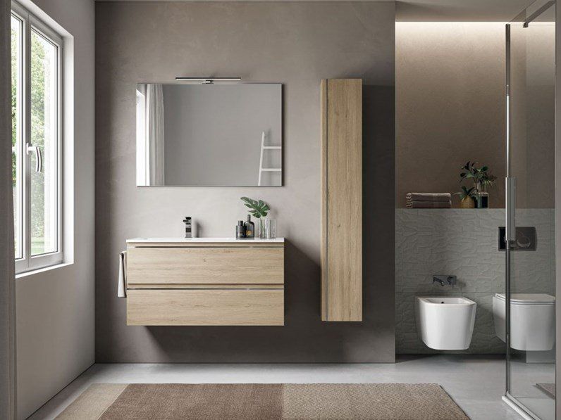 Bagno moderno con mobile lavabo in legno chiaro, specchio e doccia.