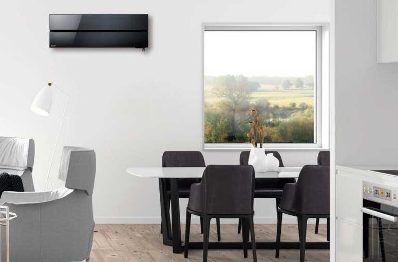 Condizionatore d'aria nero montato a parete sopra un tavolo da pranzo in un soggiorno moderno, con vista panoramica.