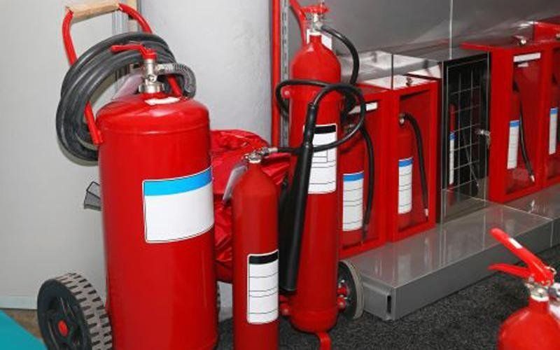 Estintori rossi e attrezzature trasportate in una stanza, pronte all'uso.