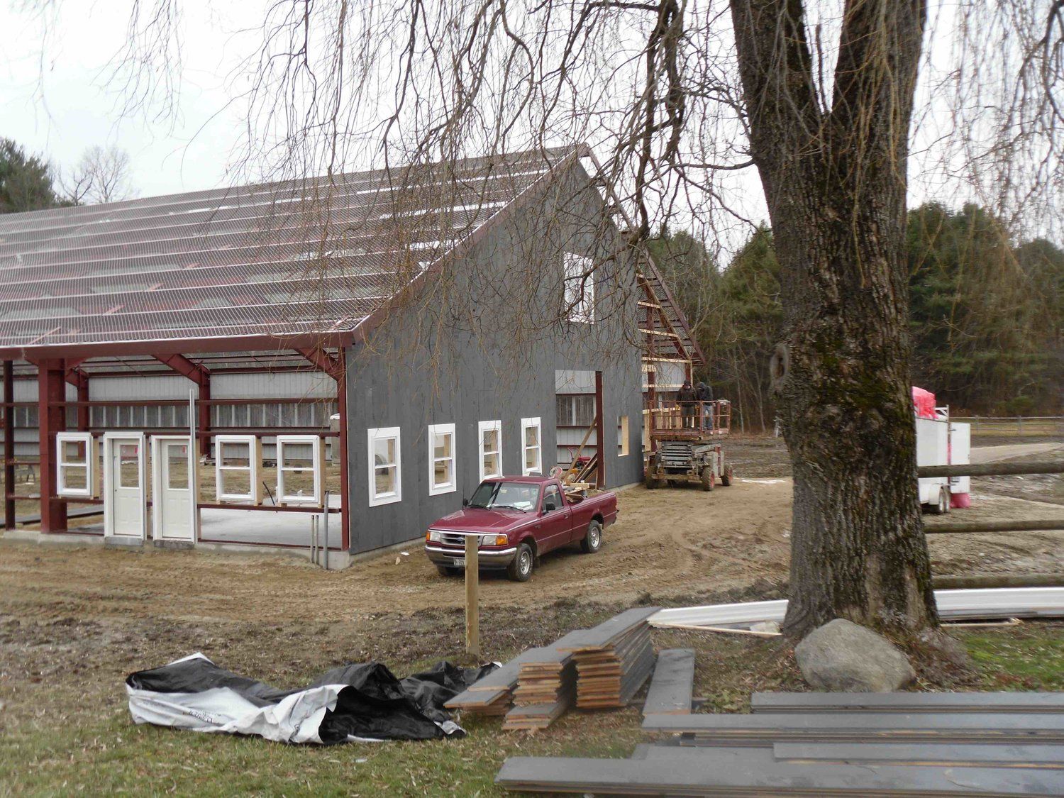 A red truck is parked in front of a building under construction