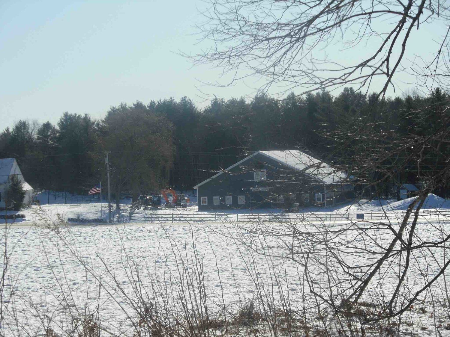 A snowy field with a house in the background
