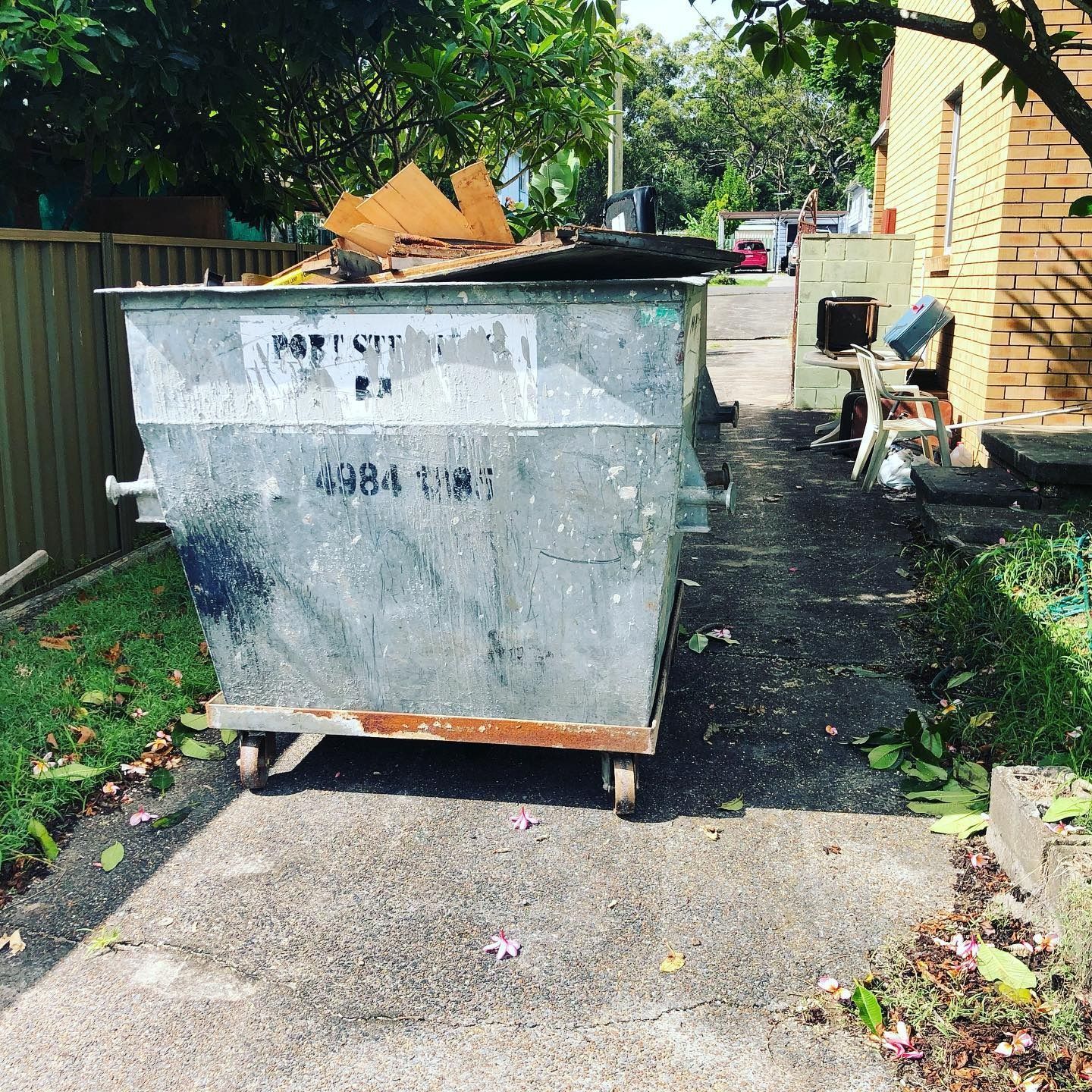 Large Metal Skip Bin Filled With Wooden Debris Large Metal Skip Bin Filled With Wooden Debris