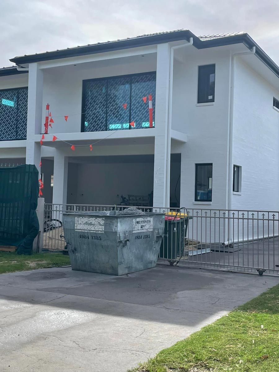 A Skip Bin In Front Of A House