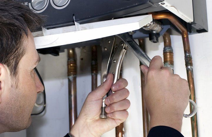 heating engineer fixing boiler pipes
