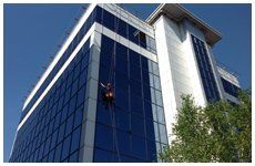 A window cleaner cleaning tower block windows
