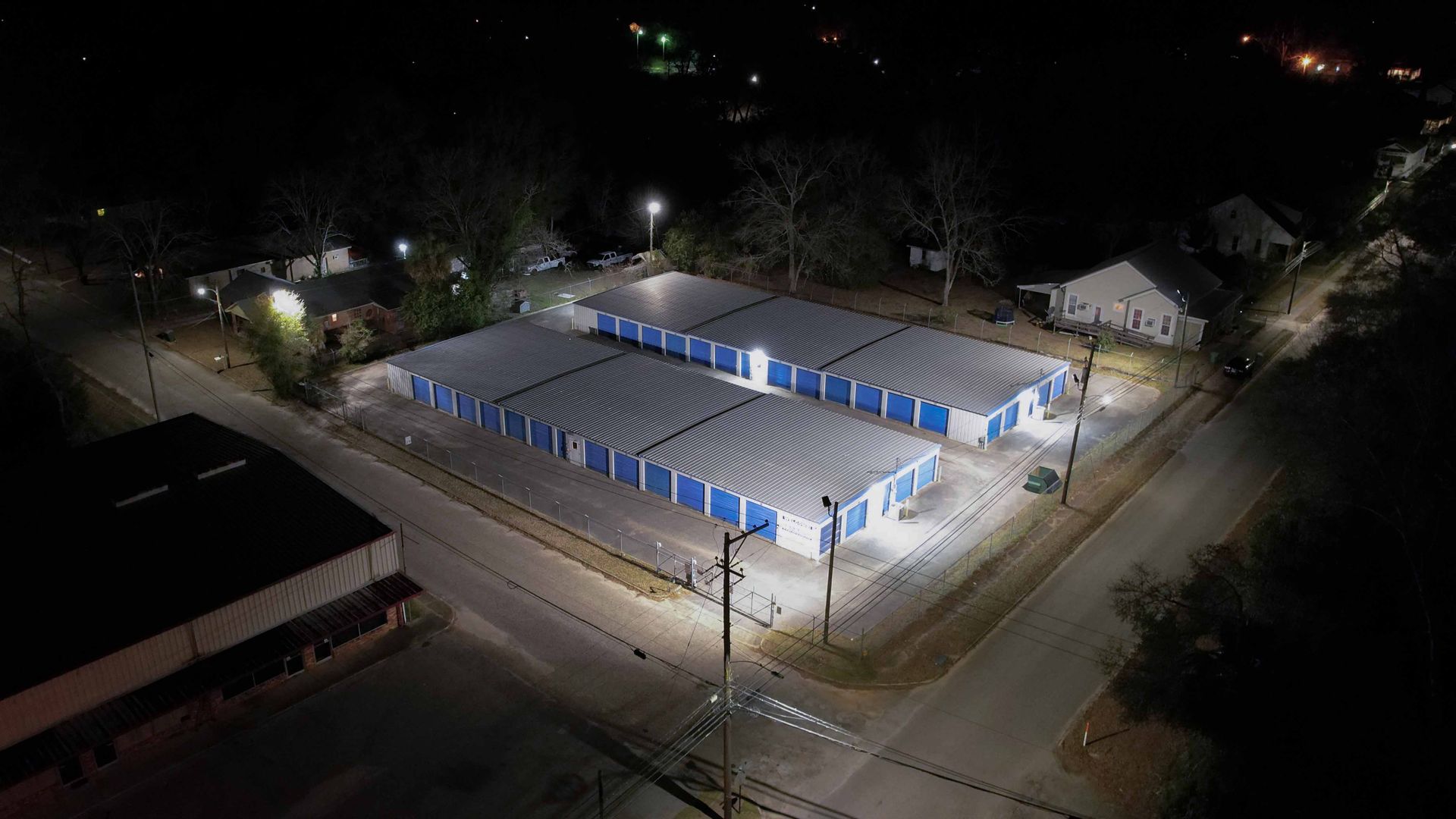 A night time Aerial View of a storage facility that has lights