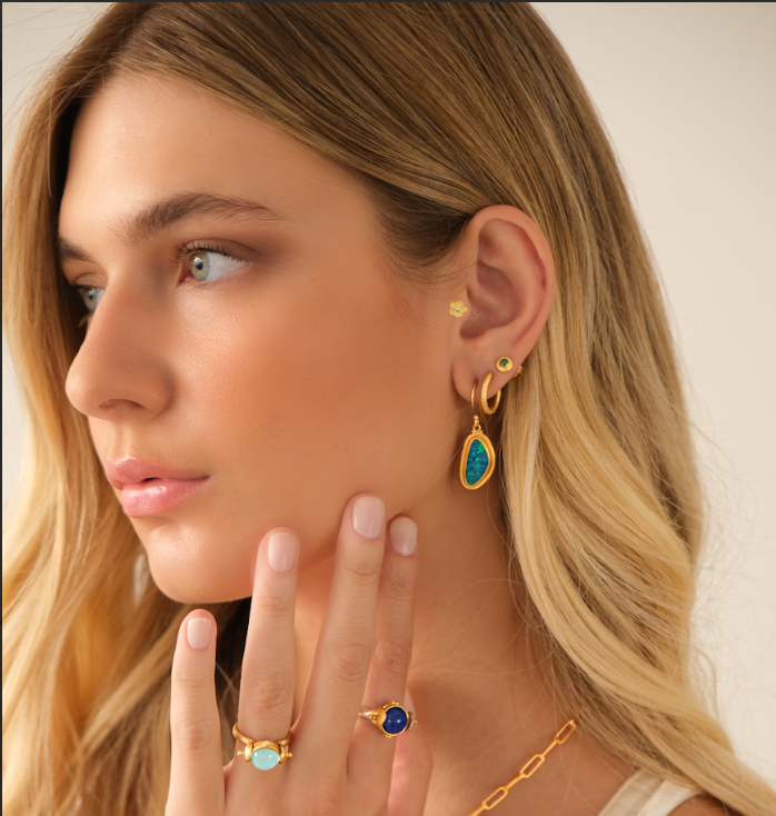 Hands clasped, wearing wedding rings: silver band on one hand, diamond engagement ring on the other.