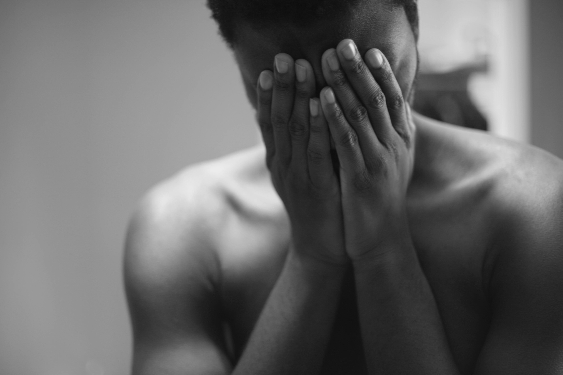 Black and white image in a gesture of emotional overwhelm or exhaustion.