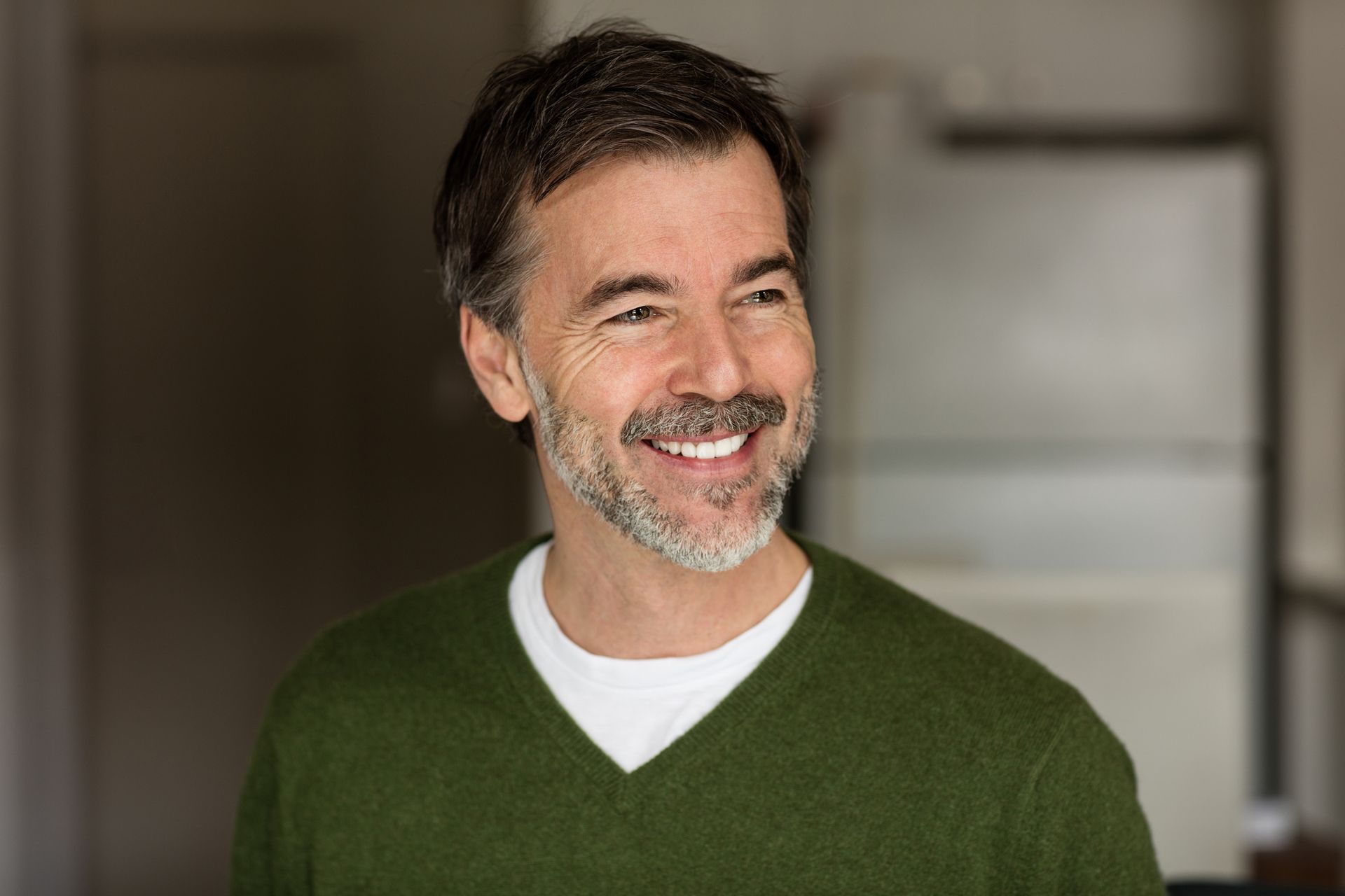 Person taking a pill with help from a healthcare provider. Pill bottle, white coat, beige pants.