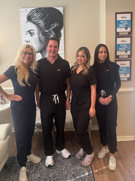 A person writing on a tablet, next to a stethoscope, fresh produce, and a smoothie.