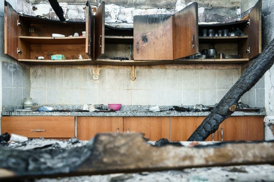 Open kitchen cabinets with heavy soot and smoke staining after a residential fire in Central Florida