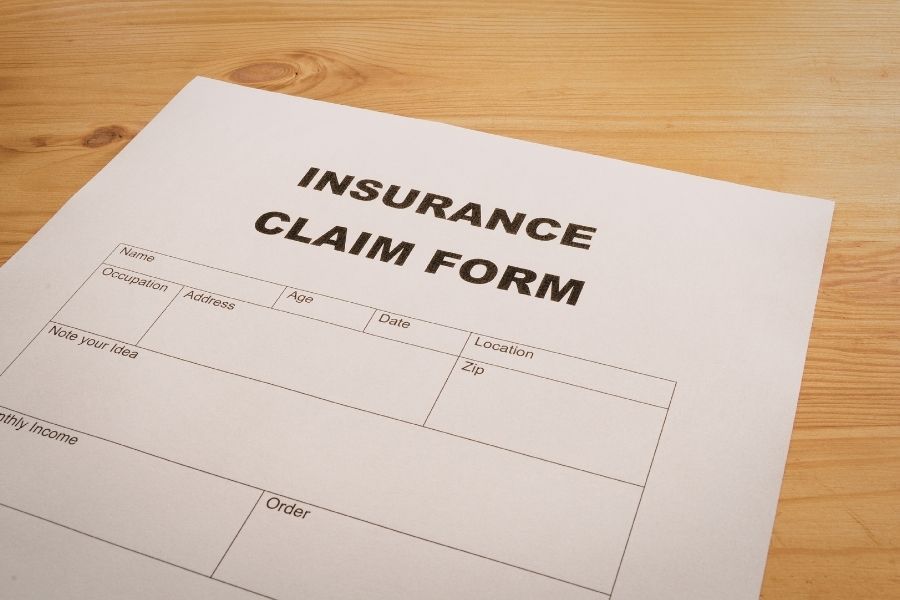 Smoke damage insurance claim form and documentation paperwork on a desk
