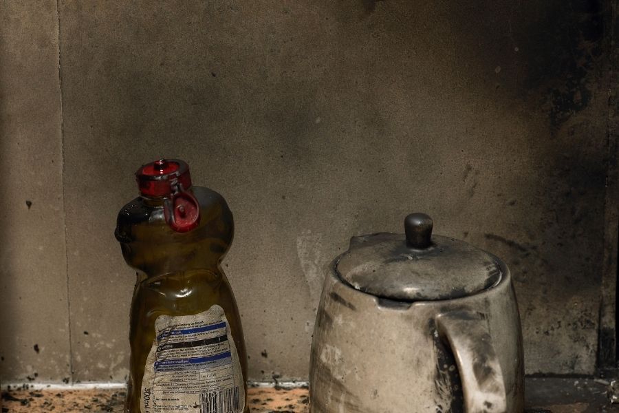 Soot-covered kitchen counter and kettle after smoke damage in a Central Florida home