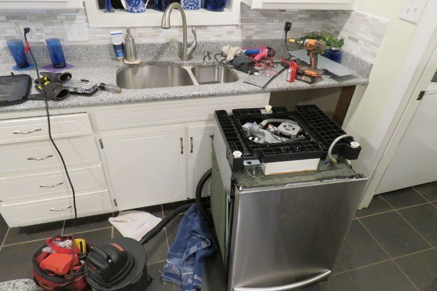 Dishwasher pulled out from cabinet for repair after water damage