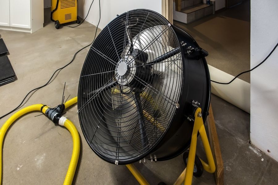 Professional air mover and dehumidifier setup during water damage restoration