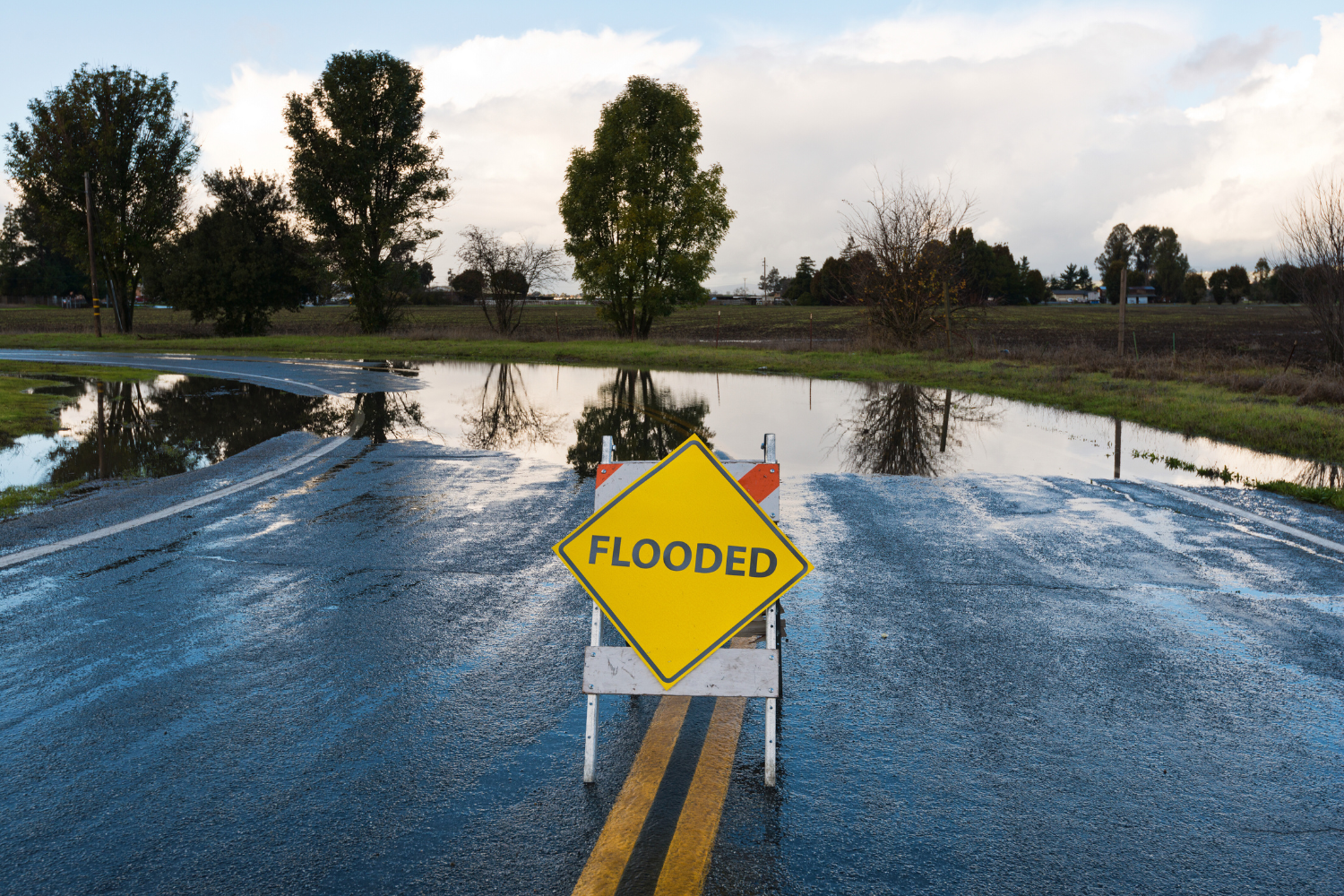 FFF's Team is serving a Flooded warning sign on a wet road in Lady Lake, FL