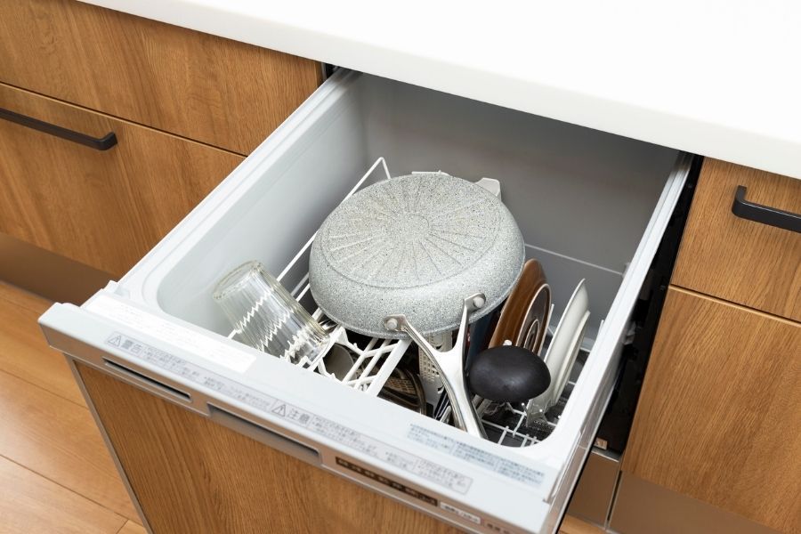 Open dishwasher full of dishes in a kitchen