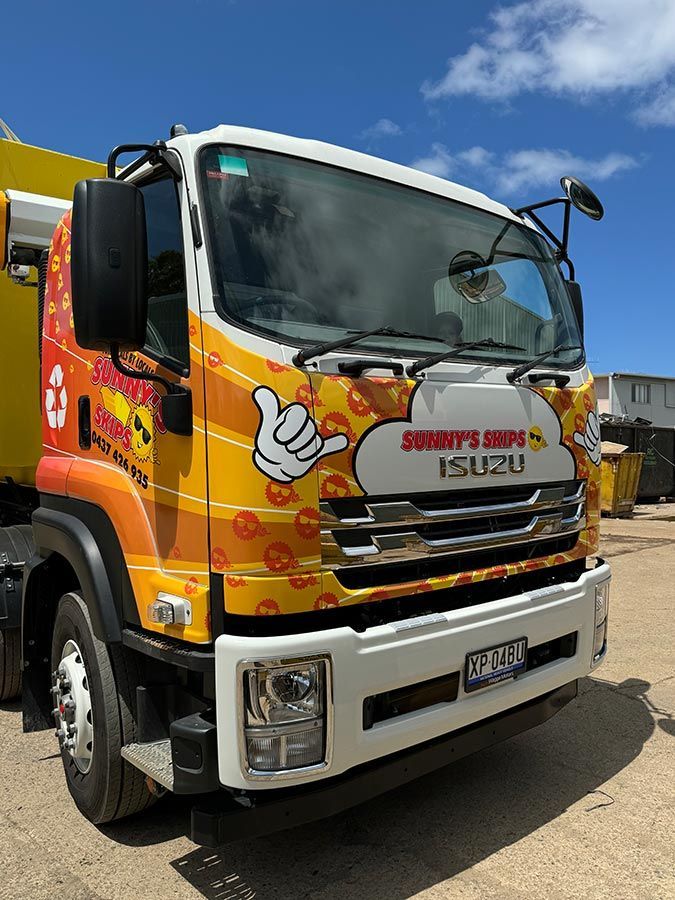 A Yellow And White Isuzu Truck Is Parked On The Side Of The Road — Sunny's Skips in Port Macquarie, NSW