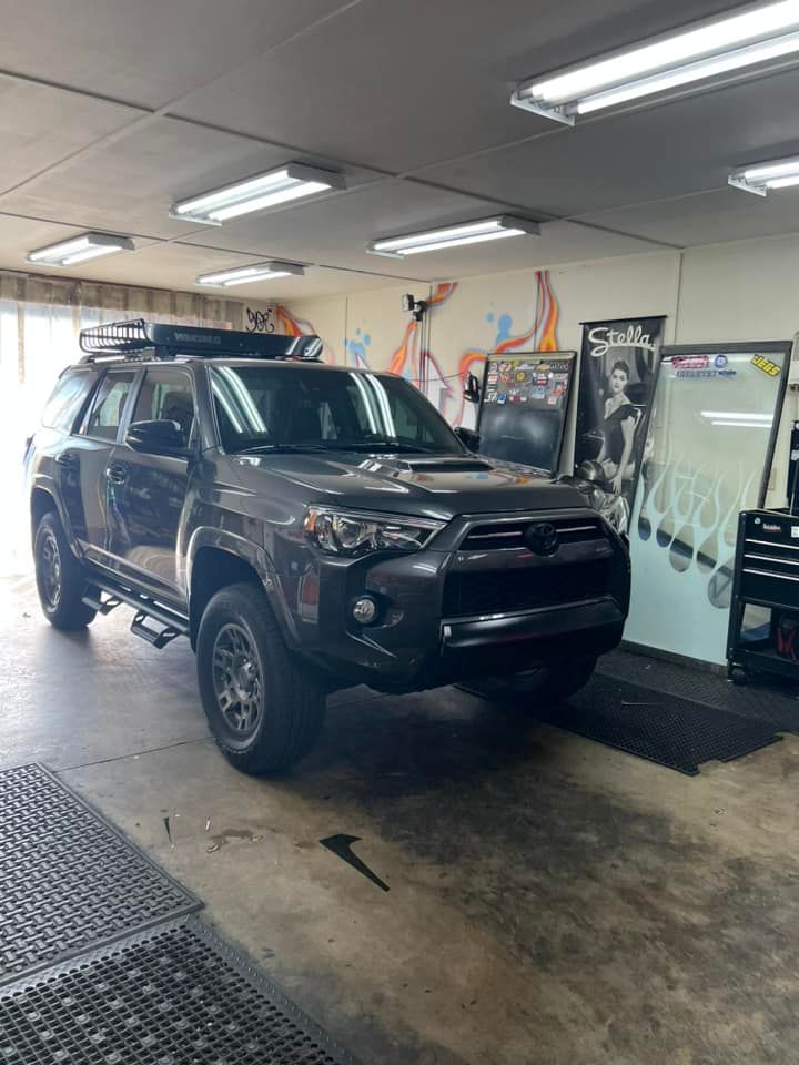 Dark gray Toyota 4Runner SUV inside a garage, equipped for off-roading.