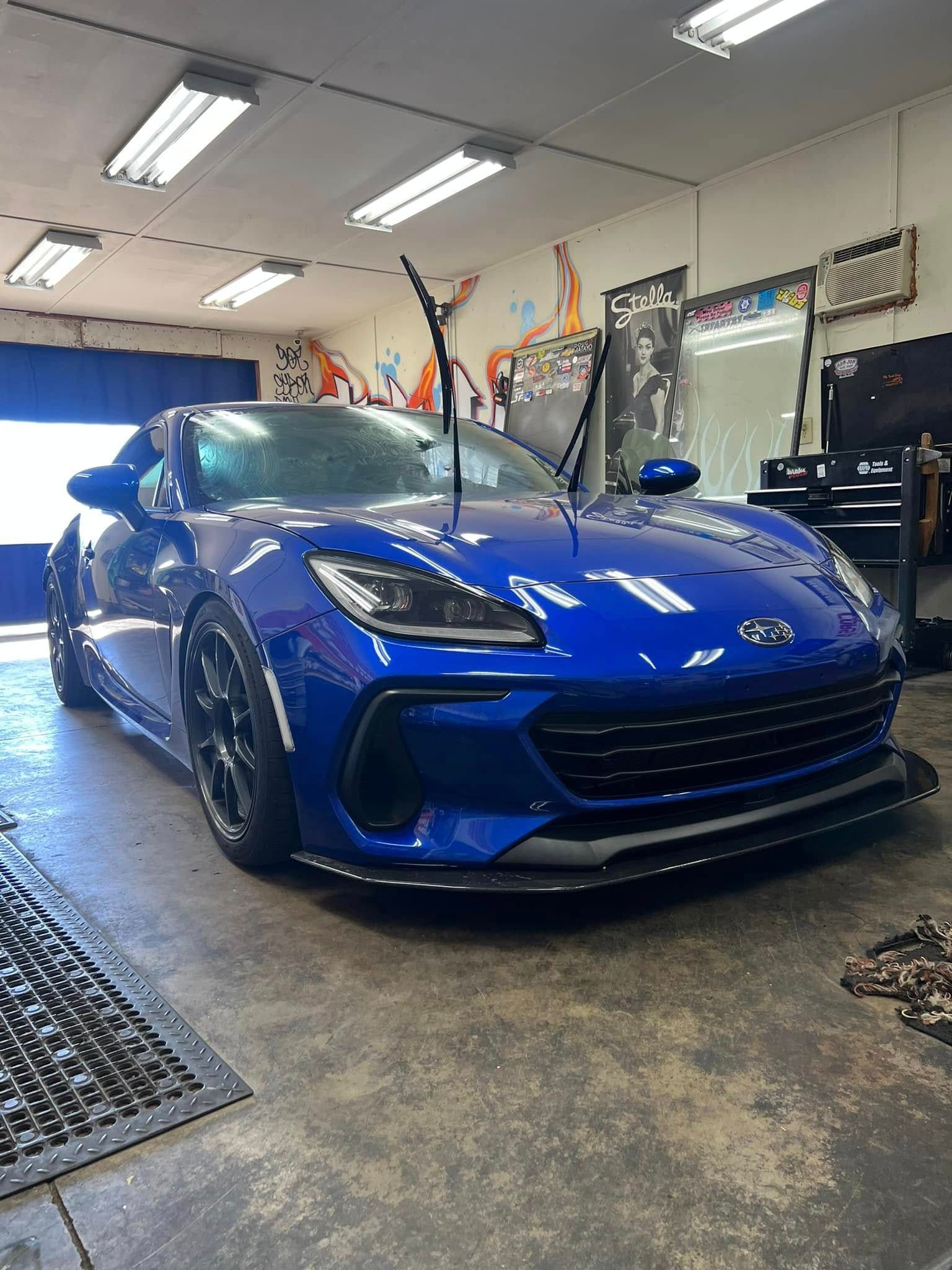 Blue Subaru sports car parked inside a garage.