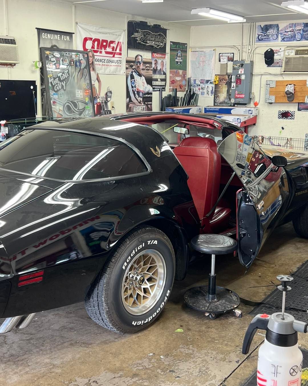 Black and red car, likely a replica of KITT from Knight Rider, in a shop setting.