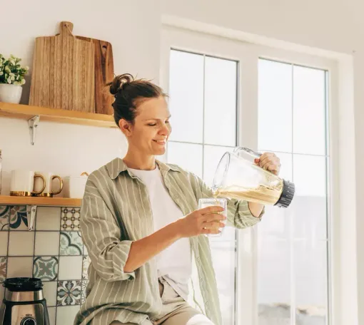 Vitaminas y suplementos en diversas botellas, algunas de ellas colocadas junto a alimentos y plantas.