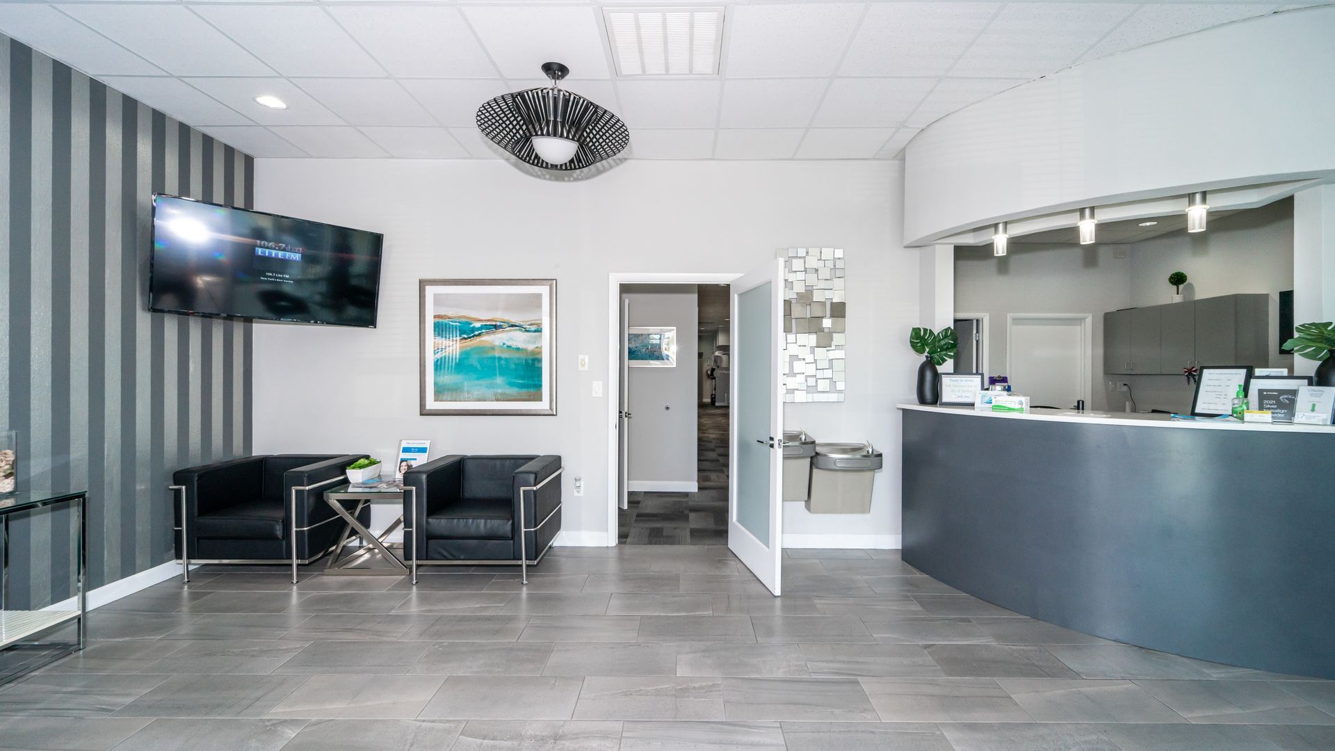 A waiting room with chairs and a counter in a dental office.