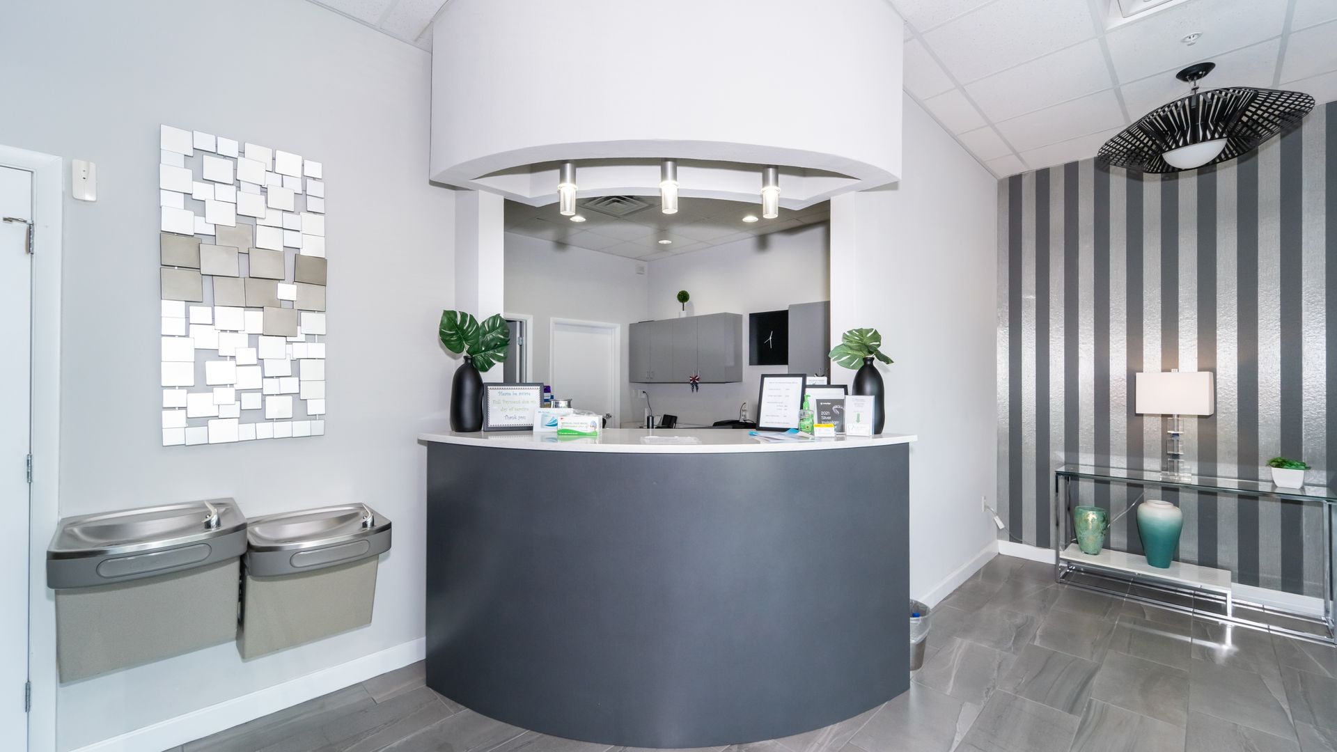 A reception desk in a dental office with a striped wall.