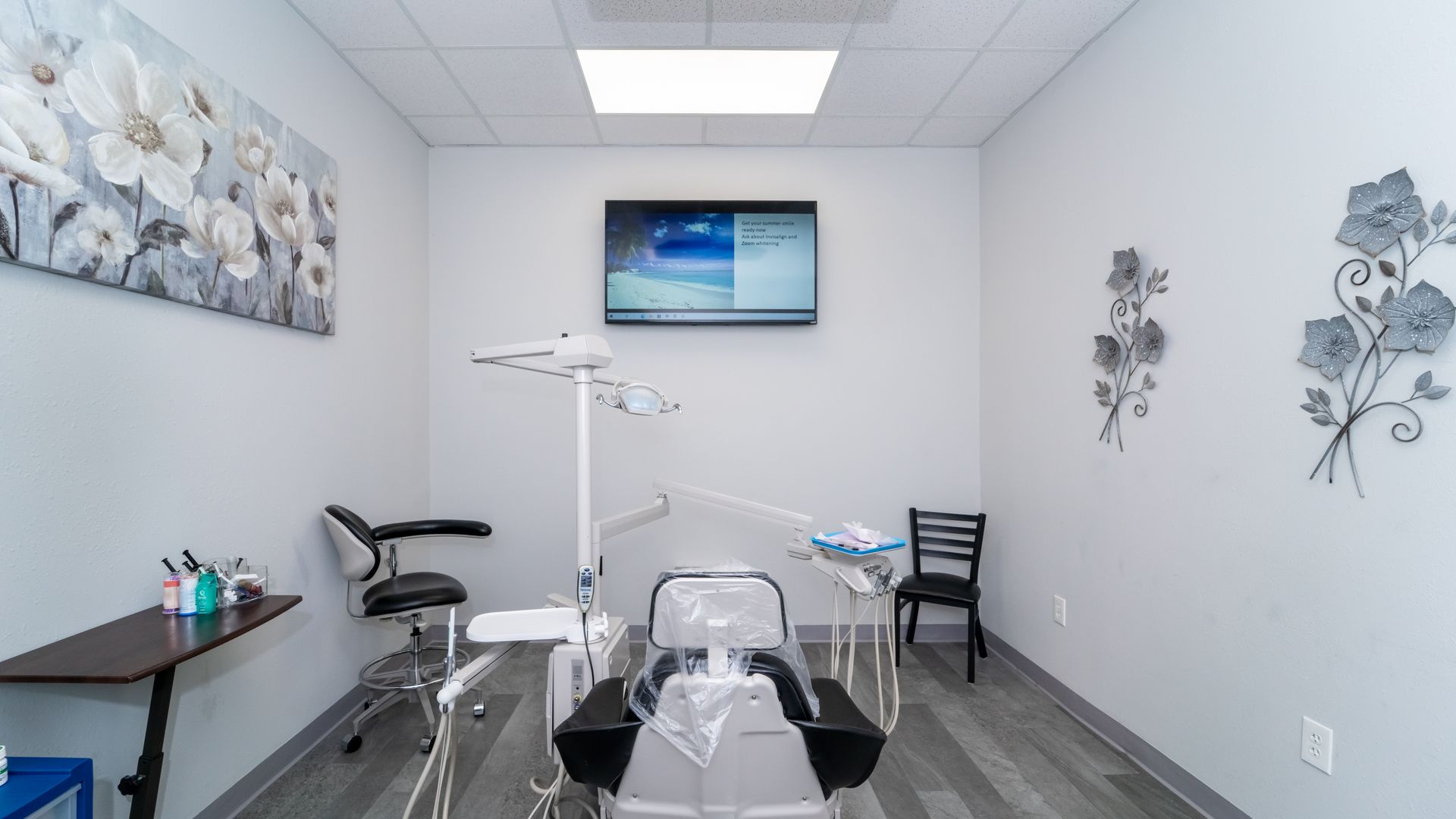 A dental office with a dental chair and a television on the wall.