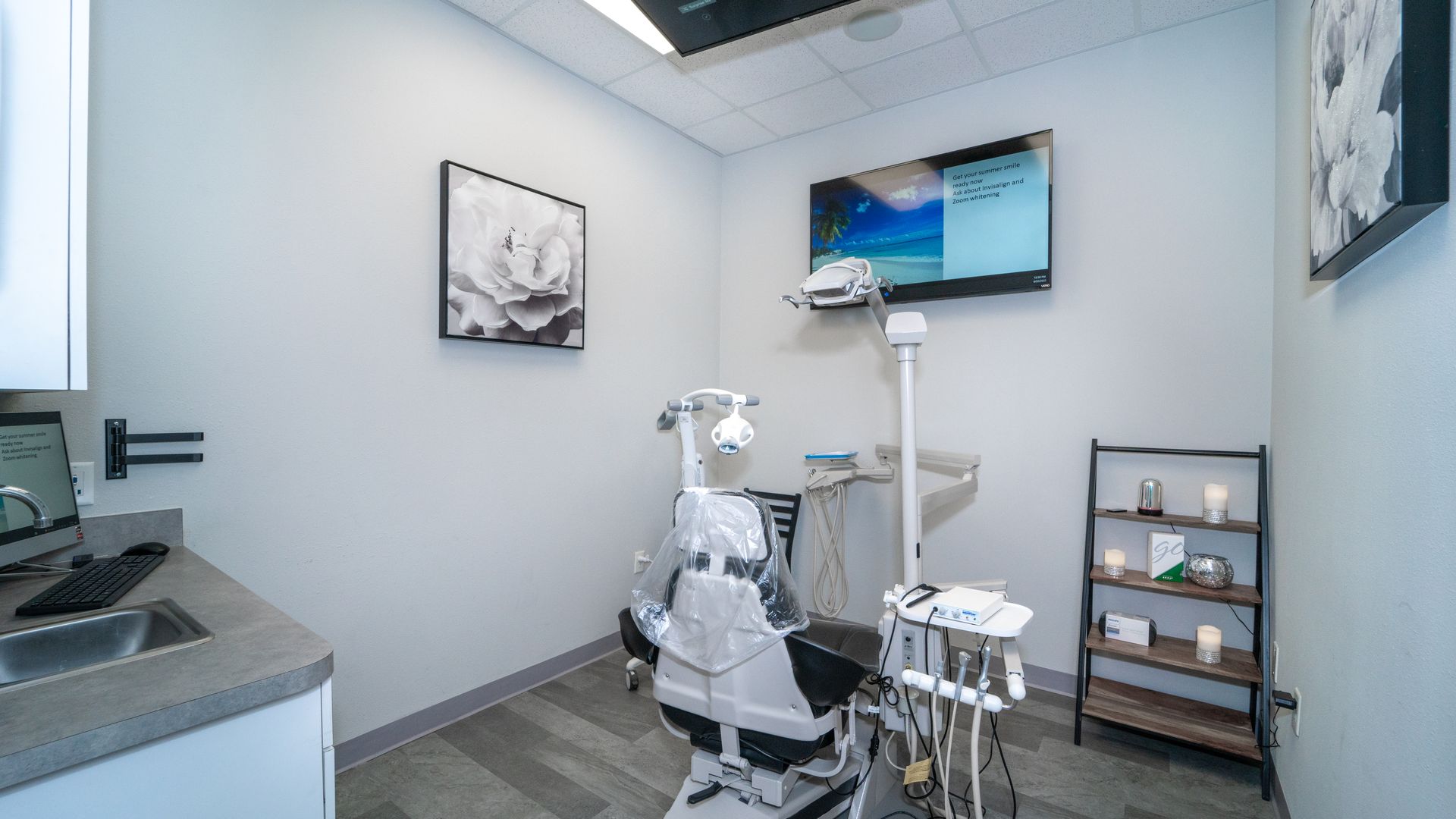 A dental office with a dental chair and a television on the wall.