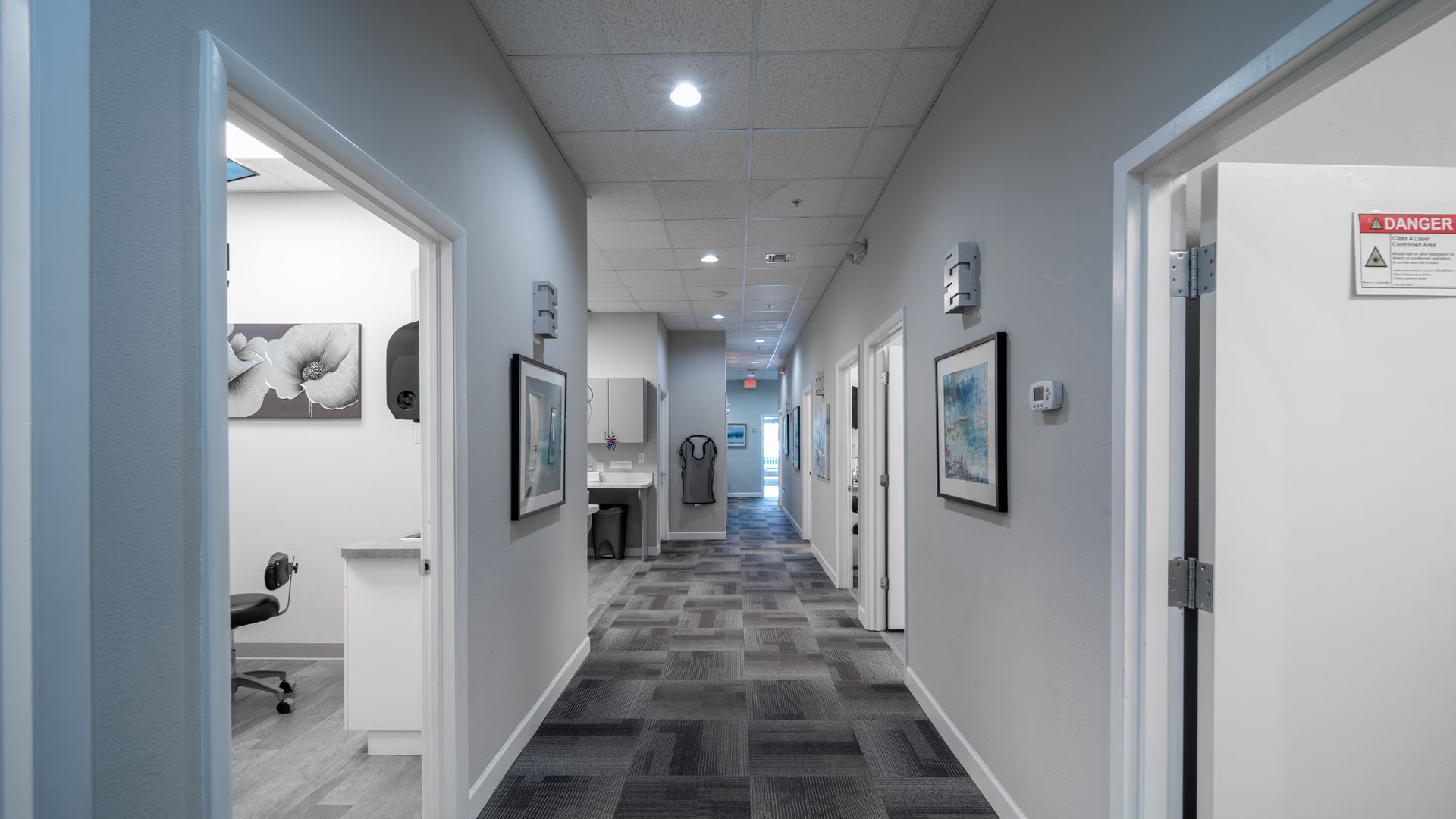 A long hallway with a lot of doors and a sign on the wall.