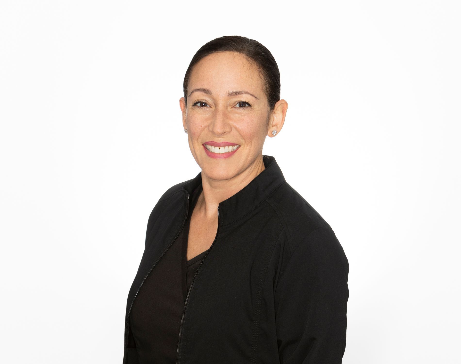 A woman in a black jacket is smiling for the camera