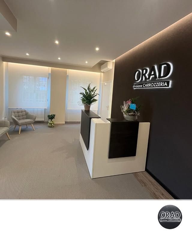 Una moderna area reception per ufficio con una parete scura con il logo 