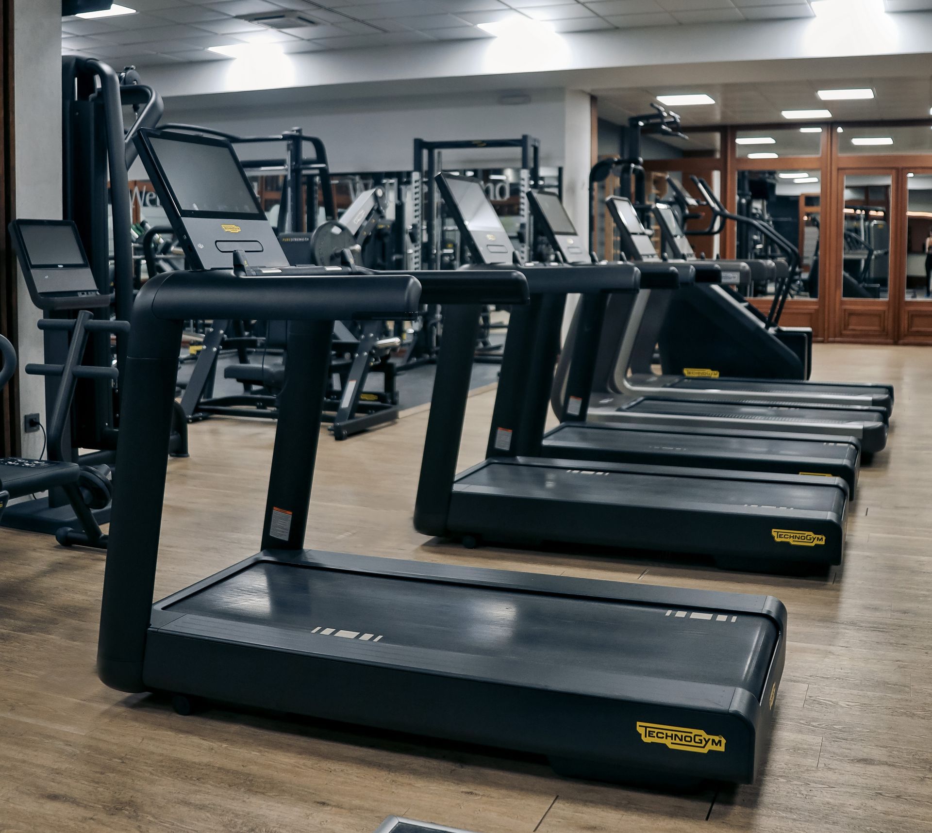 a row of treadmills are lined up in a gym .